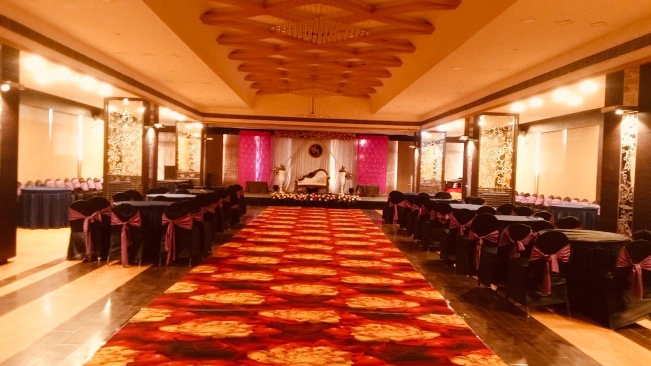 Warmly lit banquet hall with a red carpet aisle