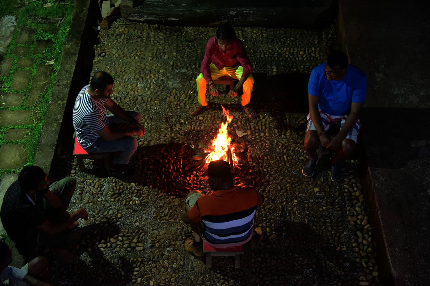 Guests sitting around a campfire at night