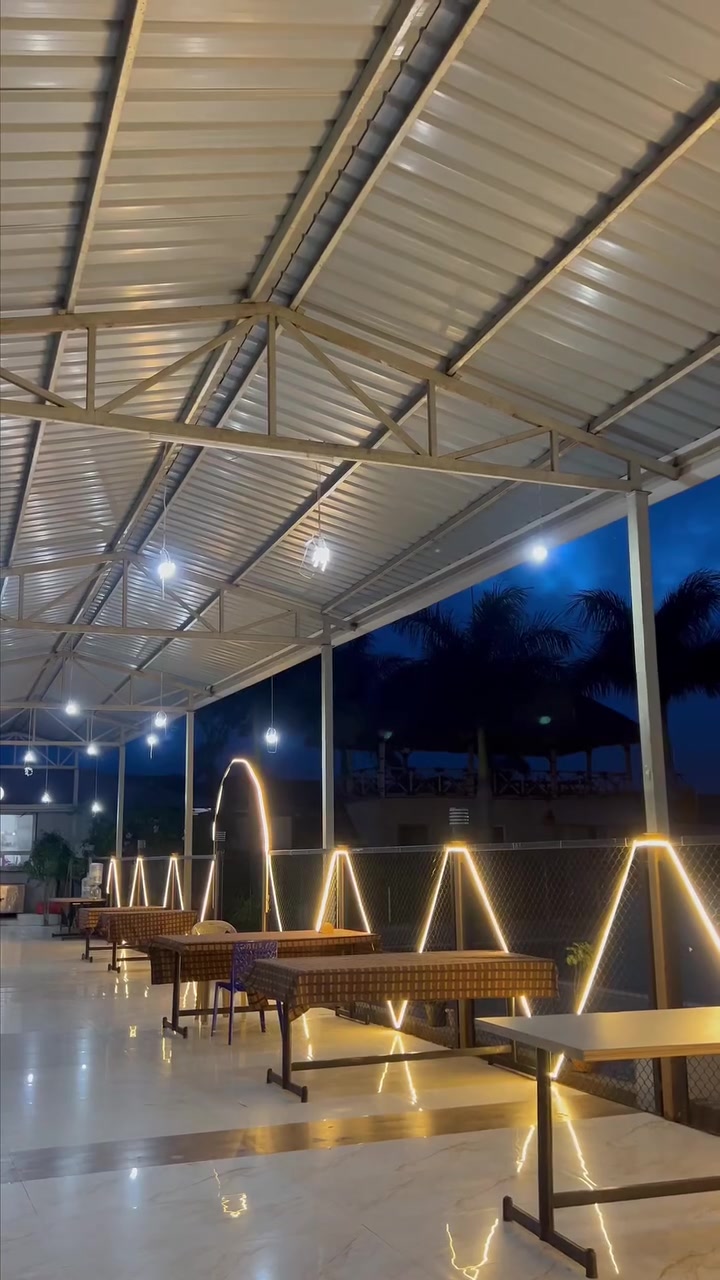 The open-air dining deck at night with lit arches