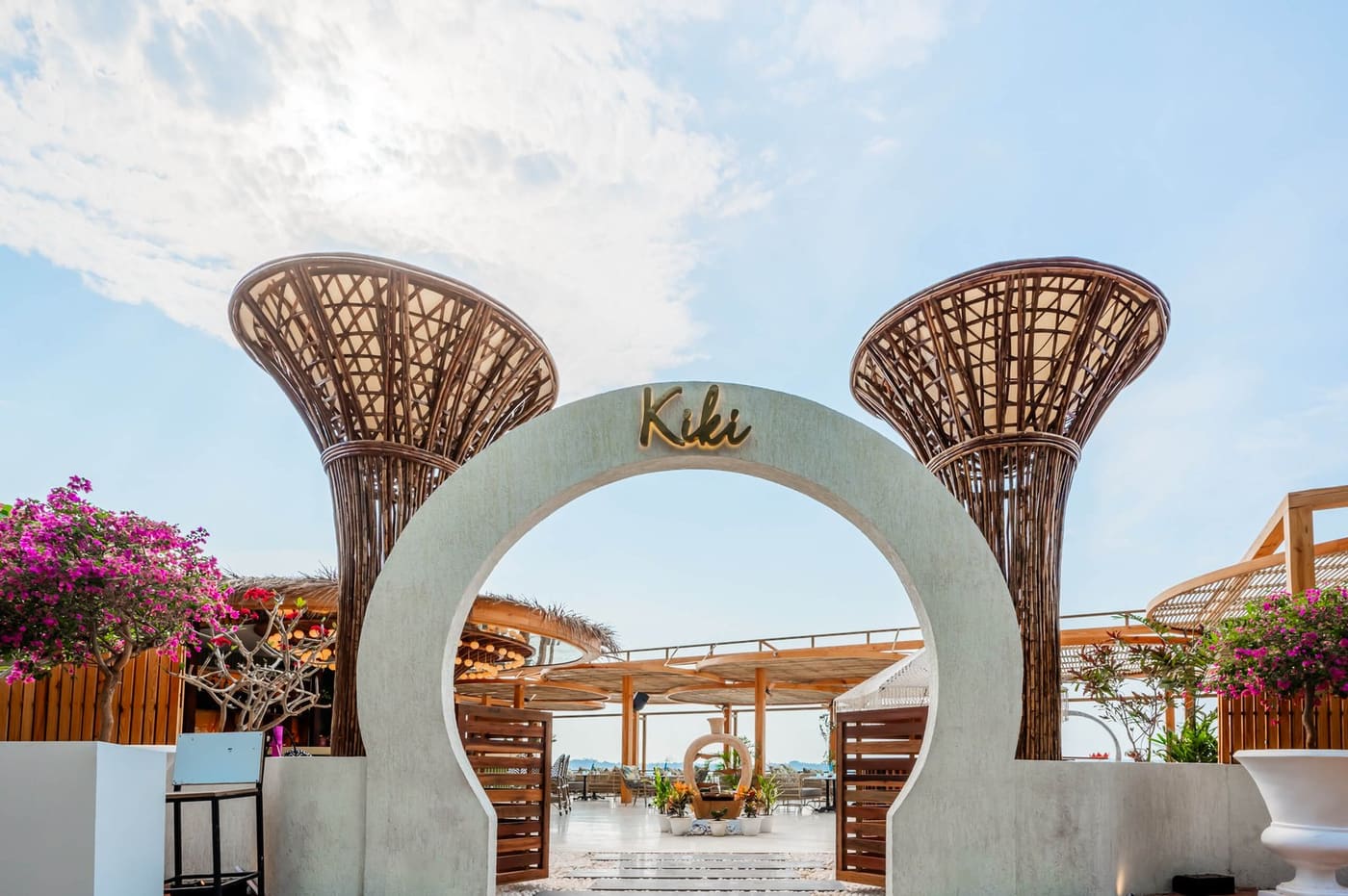 The white arch entrance framed by woven rattan trees