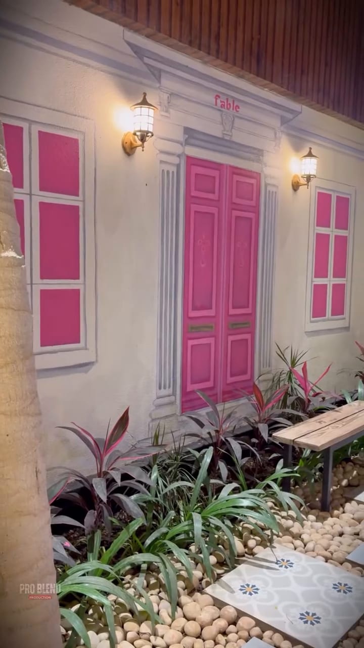 Fable's cottage front with pink double doors and shutters