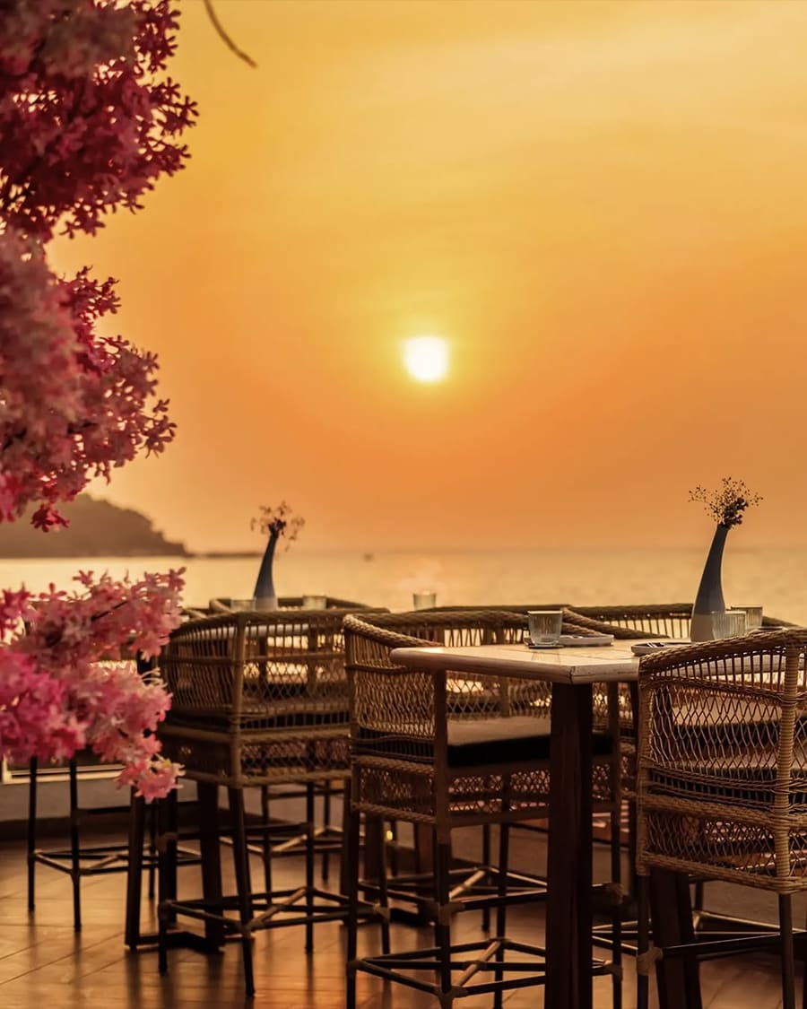 Tables on the deck as the sun sets over the sea