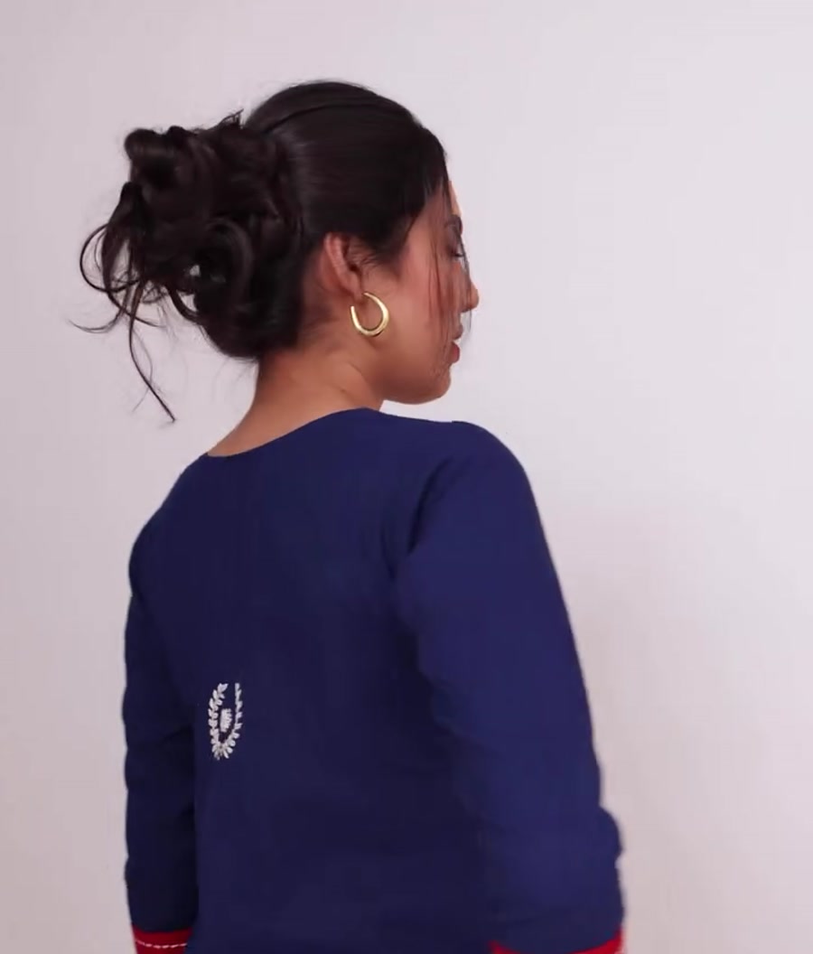 The embroidered crest on the back of an indigo kurta