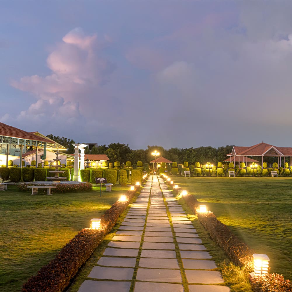 A lit stone path across the lawn at dusk