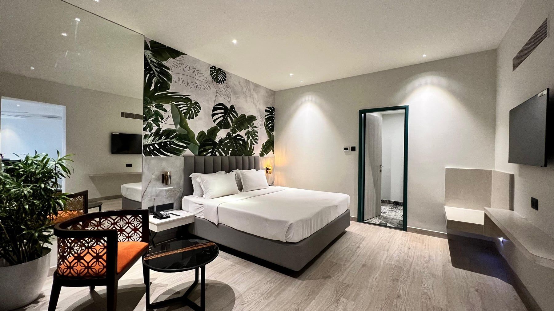 Bright room with a monstera mural and teal door