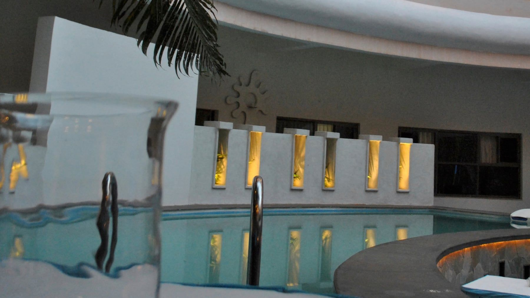 The pool beneath a curved white façade