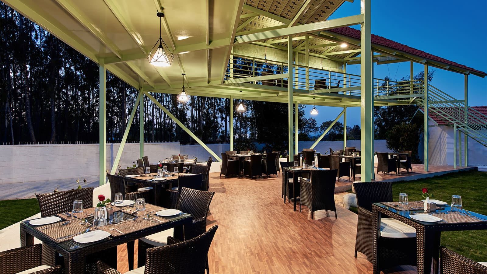 Rucira restaurant lit up at night beside the lawn