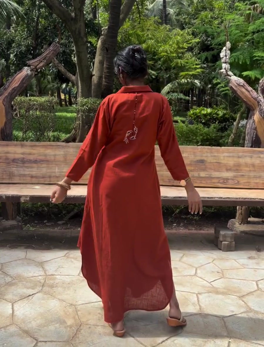 Back view of a rust shirt dress in a park