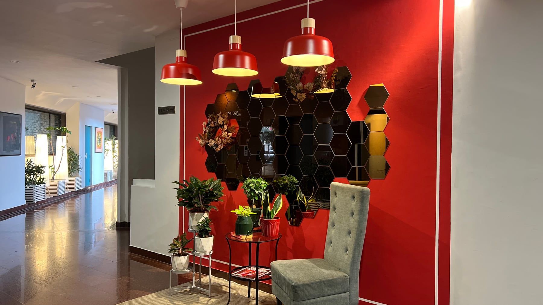 Red selfie wall with hexagon mirrors and pendant lamps