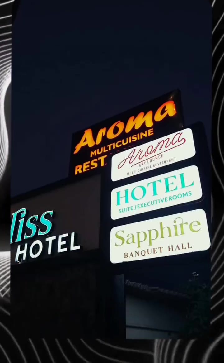 Aroma, Hotel and Sapphire signs lit up at night