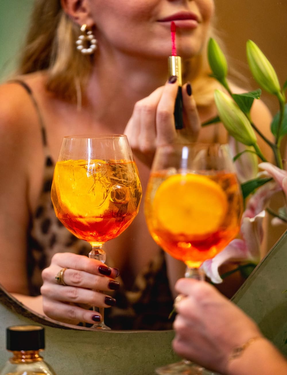 Two spritzes raised at a sea-view table