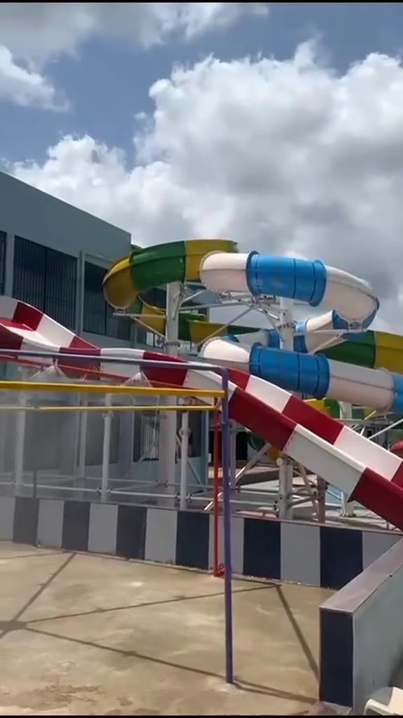 Blue, yellow and green tube slides above the red and white open slide