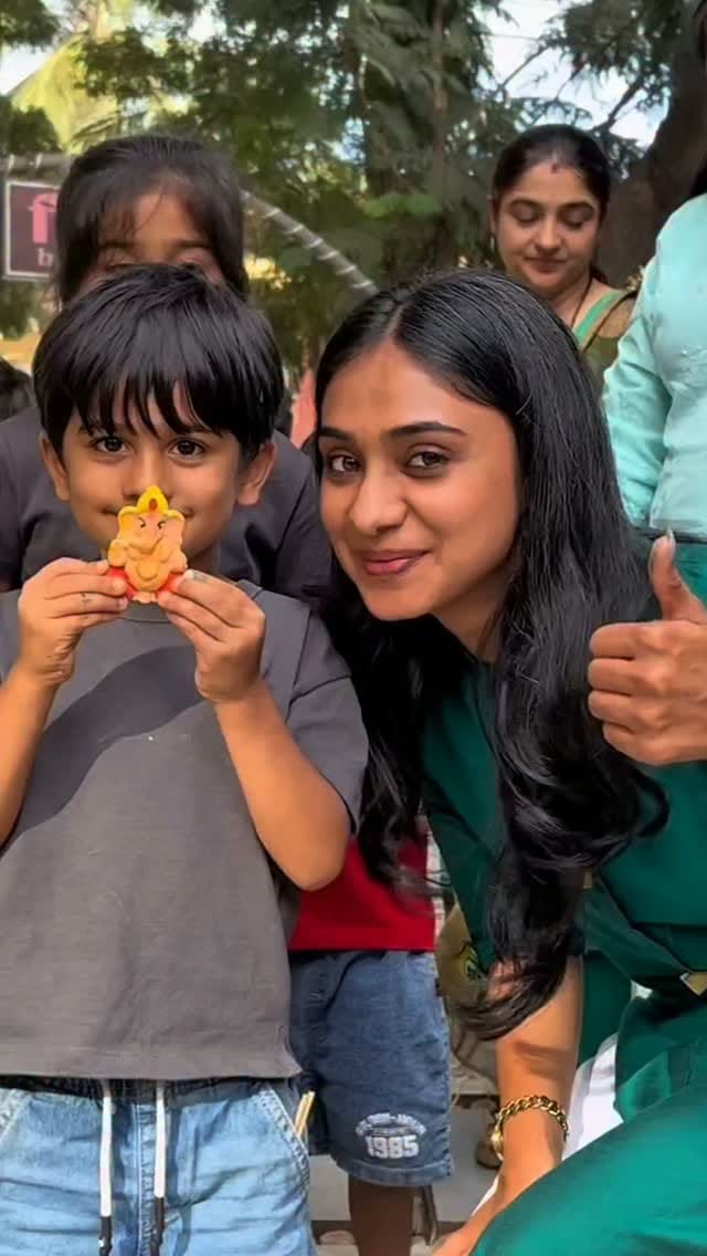 A child holding up a freshly painted Ganesha at the Fable workshop